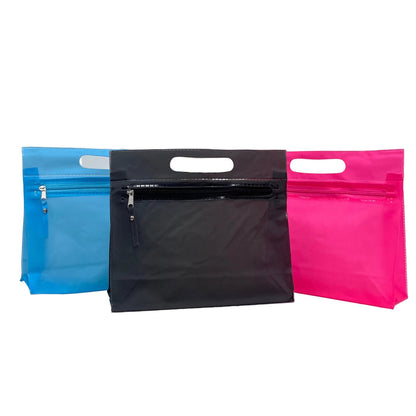 Three zip-top pouches with die-cut handles in blue, black, and pink, arranged side-by-side on a white studio background.