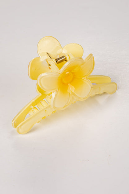 Yellow floral hair clip on a white background