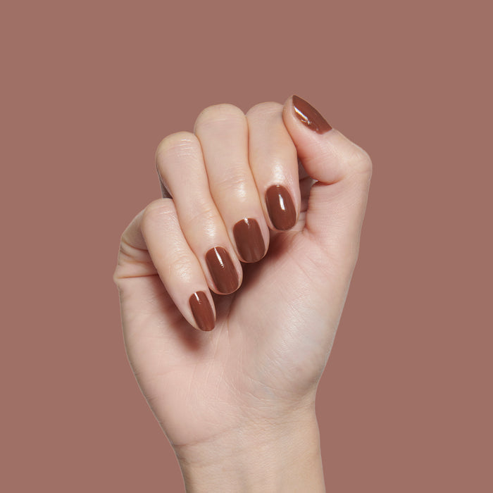 Tip Your Barista | Hand with neatly polished medium brown nails showcasing a smooth, long-lasting manicure finish
