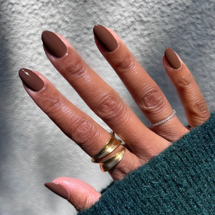 Tip Your Barista rich espresso brown long-lasting polish on almond-shaped nails with gold and silver rings visible