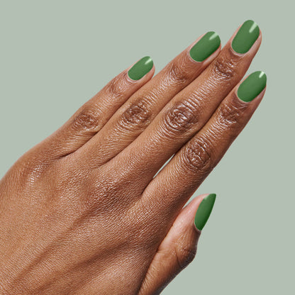 Hand with medium-length nails painted in fresh turf green Touchdown! polish for a smooth, long-lasting manicure by Olive and June