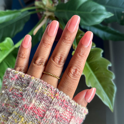 World Lit Jelly - Press-On | Short | Round with sheer mauve tones on hand wearing a cozy textured sweater for mani look